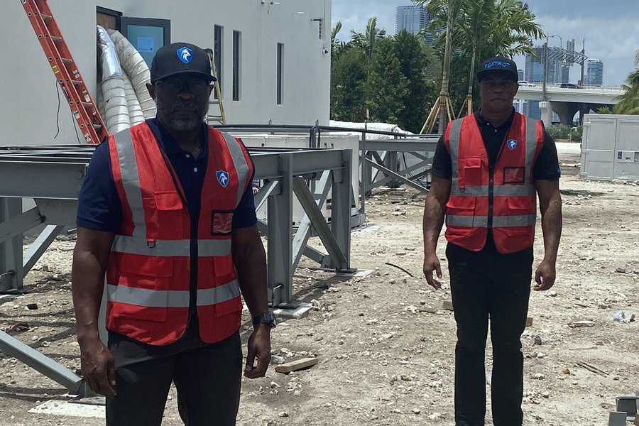 Two Foxtrot officers in high-visibility SECURITY vests on an active construction site in Miami