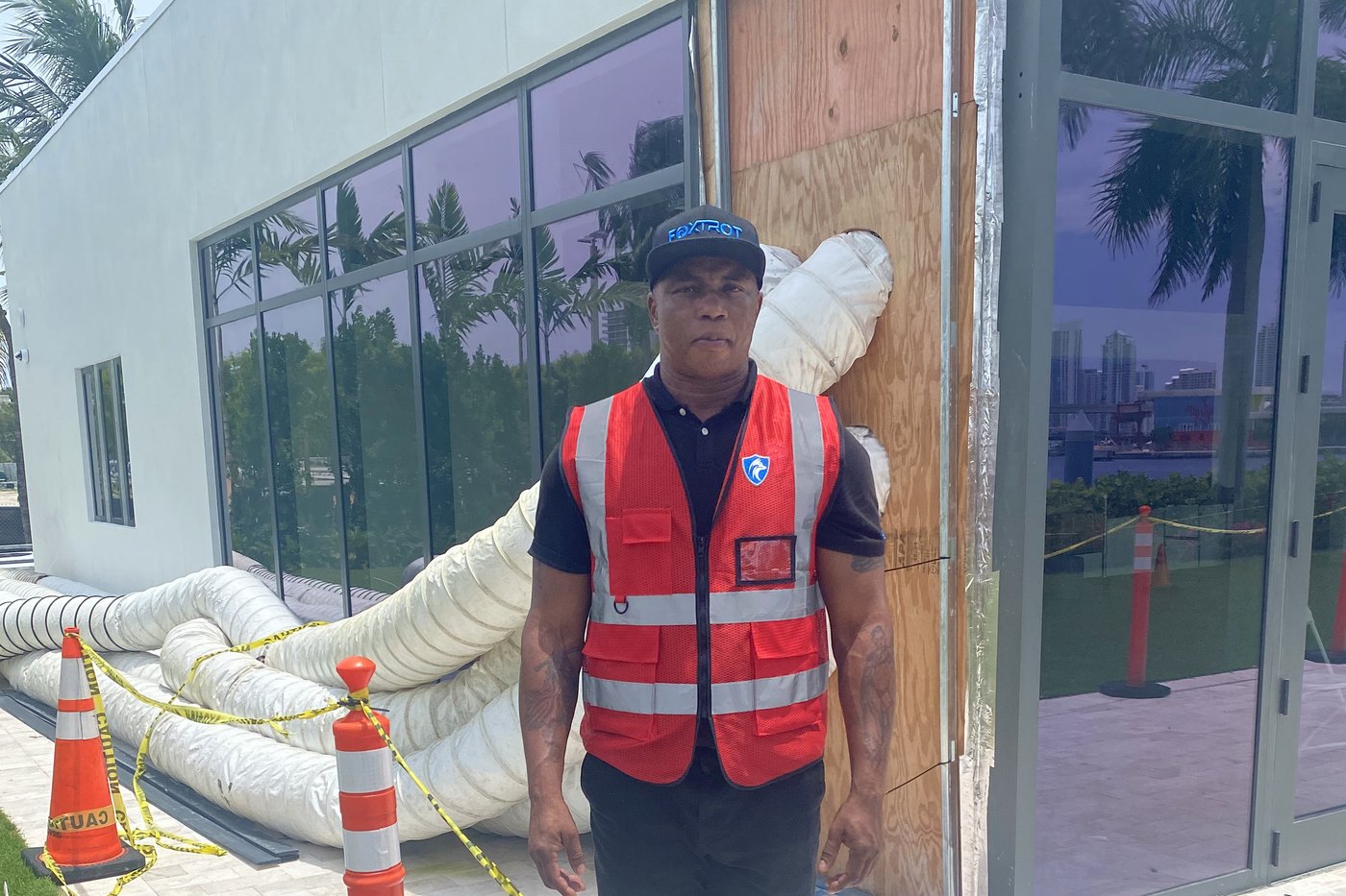 Foxtrot officer in a high-visibility SECURITY vest at a taped-off construction perimeter, Miami